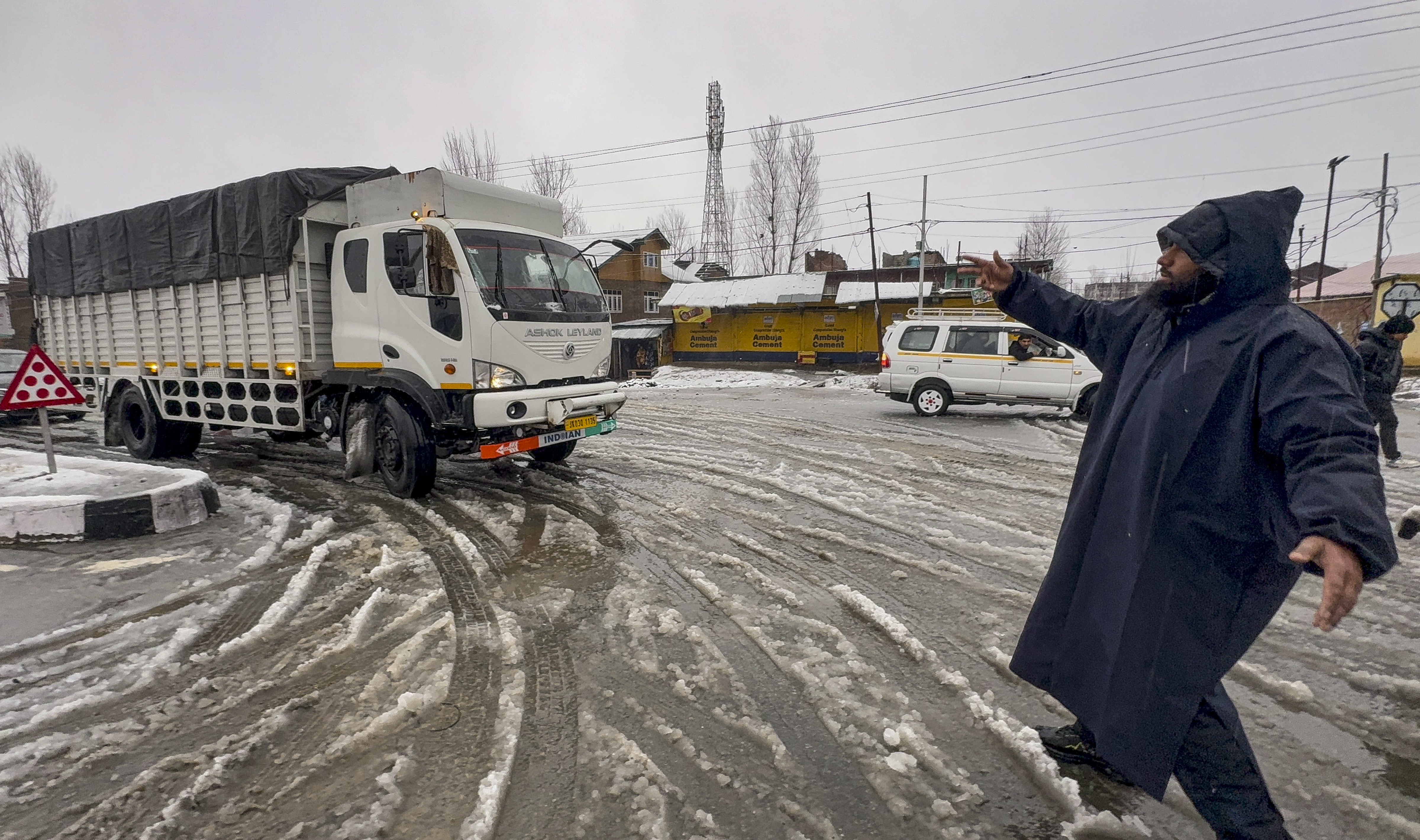 Ramban: A traffic police official regulates vehicles as traffic remains suspended on the Jammu-Srinagar National Highway (NH-44) following fresh snowfall, in Ramban district, Jammu and Kashmir, Friday, Jan. 23, 2026. (PTI Photo) (PTI01_23_2026_000037A)